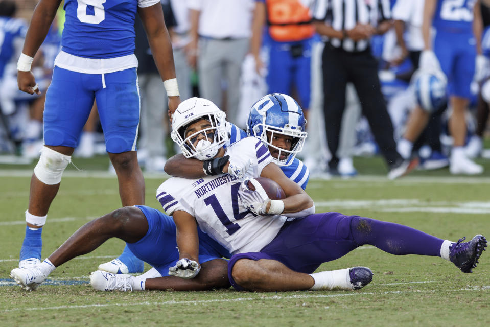 Northwestern's Cam Johnson (14) is tackled by Duke's Al Blades Jr., right, during the second half of an NCAA college football game in Durham, N.C., Saturday, Sept. 16, 2023. (AP Photo/Ben McKeown)