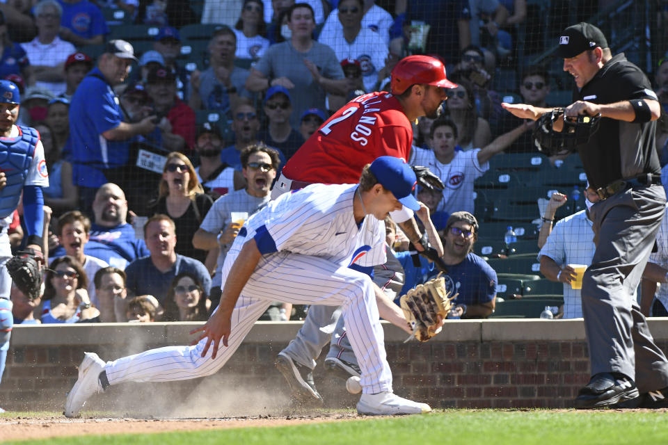 Cincinnati Reds' Nick Castellanos (2) scores past Chicago Cubs relief pitcher Codi Heuer, front, on a wild pitch during the sixth inning of a baseball game, Monday, Sept. 6, 2021, in Chicago. (AP Photo/Matt Marton)