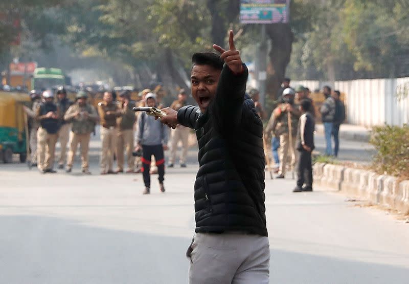 Man reacts as he brandishes a gun during a protest against a new citizenship law outside the Jamia Millia Islamia university in New Delhi