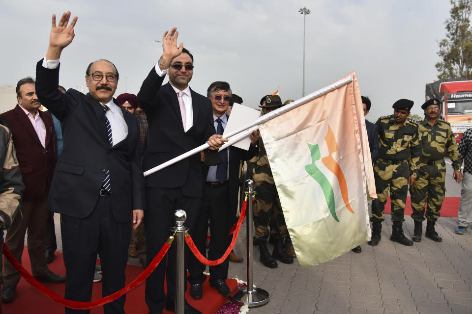 India’s foreign secretary Harsh Vardhan Shringla, left, and Afghanistan’s ambassador to India Farid Mamundzay wave after flagging off the trucks carrying wheat from India at the Attari-Wagah border between India and Pakistan, near Amritsar, India, Tuesday, Feb. 22, 2022. India's foreign ministry says it has sent off tons of wheat to Afghanistan to help relieve desperate food shortages, after New Delhi struck a deal with neighboring rival Pakistan to allow the shipments across the shared border. (AP Photo/Prabhjot Gill)