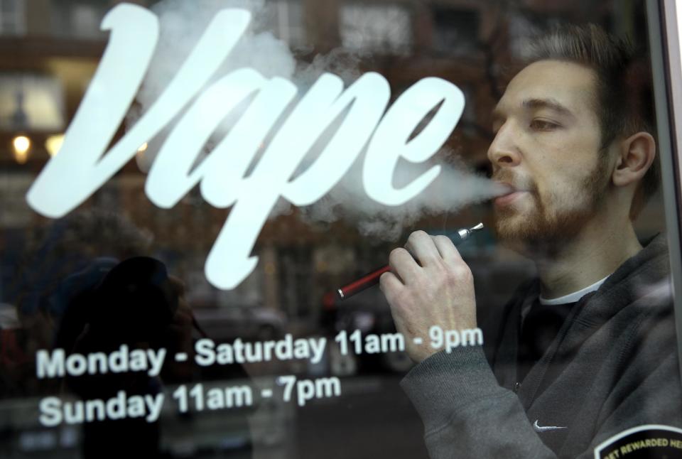 Eric Scheman demonstrates an e-cigarette at Vape store in Chicago, Wednesday, April 23, 2014. The federal government wants to ban sales of electronic cigarettes to minors and require approval for new products and health warning labels under regulations being proposed by the Food and Drug Administration. (AP Photo/Nam Y. Huh)