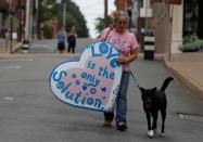 <p>A woman walks with her dog to a memorial for Heather Heyer ahead of the one-year anniversary of 2017 Charlottesville “Unite the Right” protests, in Charlottesville, Va., Aug. 11, 2018. (Photo: Jim Urquhart/Reuters) </p>