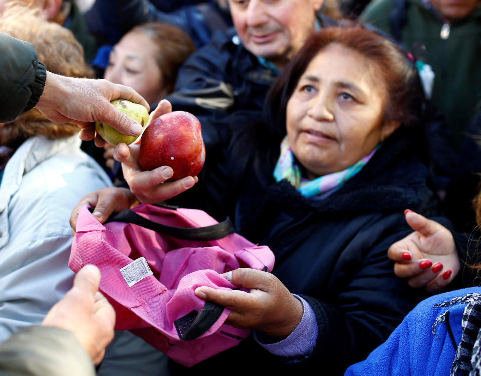 <p>People receive free pears and apples during a protest staged by Argentine producers and farmers from the Patagonian provinces of Neuquen and Rio Negro for their losses in the activity in Buenos Aires, Argentina, Aug. 23, 2016. (Enrique Marcarian/Reuters) </p>