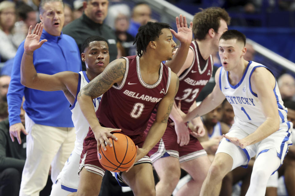 Bellarmine's Jaylen Fairman (0) looks for an opening as Kentucky's Sahvir Wheeler, left, and CJ Fredrick (1) defend during the first half of an NCAA college basketball game in Lexington, Ky., Tuesday, Nov. 29, 2022. (AP Photo/James Crisp)