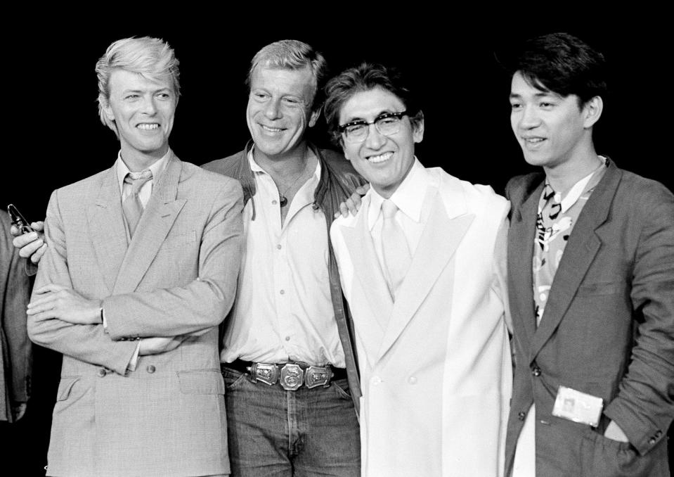 ARCHIVO – El equipo que creó la película "Merry Christmas, Mr. Lawrence" en París, el 11 de mayo de 1983. De izquierda a derecha: el actor David Bowie, el productor Jack Thomas, el director Nagisa Oshima y el compositor y actor Ryuichi Sakamoto. La empresa discográfica japonesa Avex dijo que Sakamoto, quien hizo la música de películas como "The Last Emperor" y "The Revenant", ha muerto. Tenía 71 años. Falleció el 28 de marzo de acuerdo con un comunicado enviado el 2 de abril de 2023. (Foto AP/Jacques Langevin, archivo)