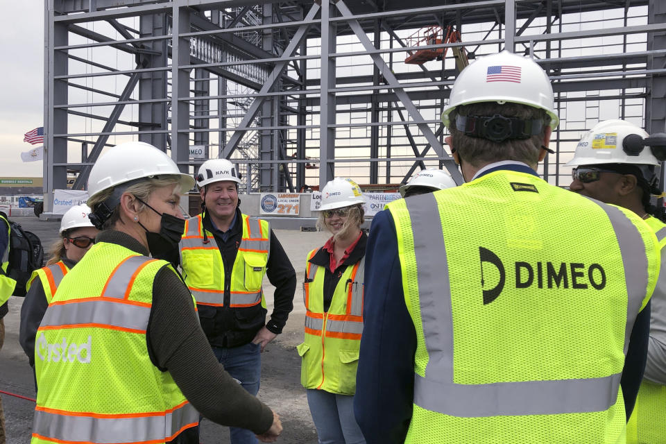 U.S. Energy Secretary Jennifer Granholm, left, speaks with workers, and Rhode Island Gov. Dan McKee., right, Thursday Dec. 2, 2021, while visiting an under construction fabrication and assembly facility for offshore wind turbines at the Port of Providence, in Providence, R.I. The building is scheduled to be finished this spring to support two offshore wind projects, Revolution Wind and South Fork Wind. (AP Photo/Jennifer McDermott)