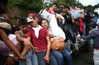 Honduran migrants, part of a caravan trying to reach the U.S., are pictured on a truck during a new leg of their travel in Zacapa, Guatemala October 17, 2018. REUTERS/Edgard Garrido