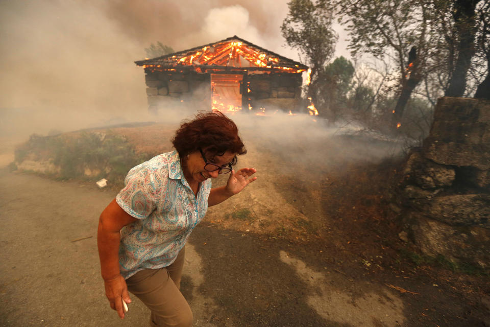 A woman runs away from a burning house