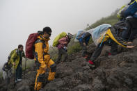 People climb the steep slope of Mount Fuji on Monday, Aug. 26, 2019, in Japan. It takes an average hiker five to six hours to reach the summit. (AP Photo/Jae C. Hong)