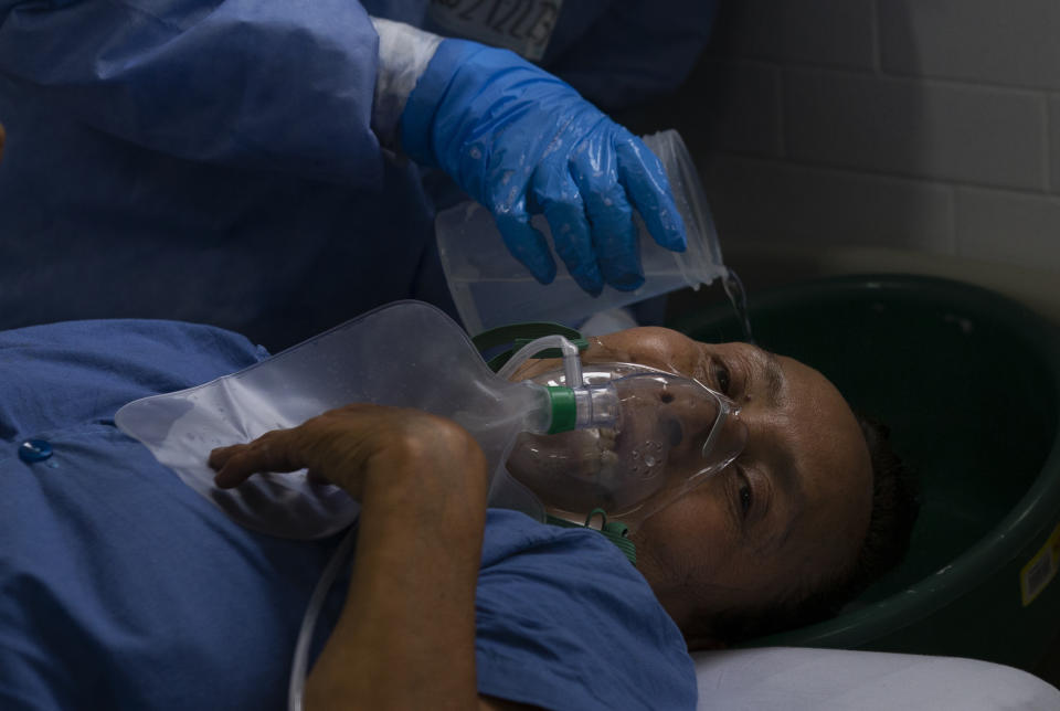 Dressed in protective gear to curb the spread of the new coronavirus, a medical worker washes a patient's hair, at a military hospital set up to take care of COVID-19 patients in Mexico City, Monday, November 30, 2020. As of last Friday, Mexico reported a record daily increase in the number of coronavirus cases, with Mexico City reporting the biggest portion of the surge in cases. (AP Photo/Marco Ugarte)