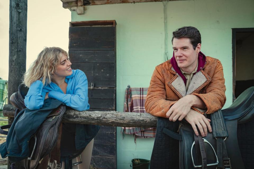 Connor Swindells with a woman behind a fence in ‘Sex Education’