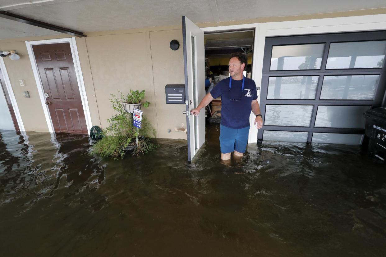 Rudy Horvath walks out of his home, a boathouse in the West End section of New Orleans, as it takes on water a from storm surge in Lake Pontchartrain in advance of Tropical Storm Cristobal: AP Photo/Gerald Herbert