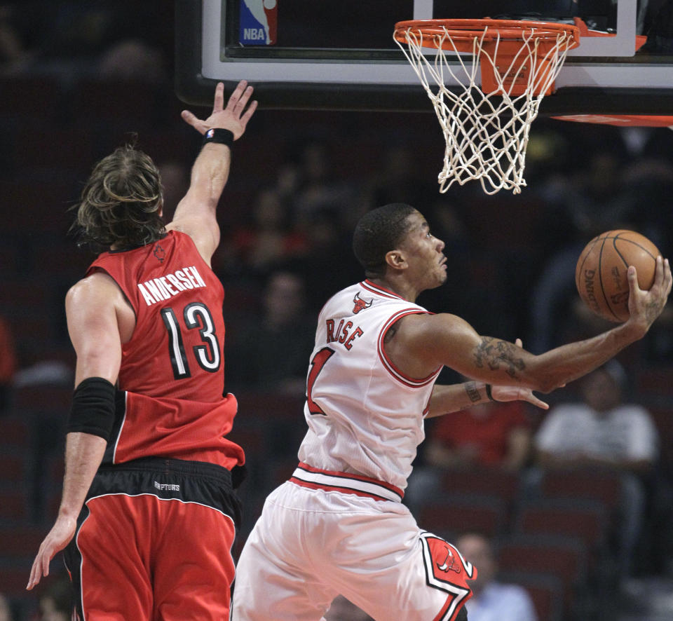 Chicago Bulls point guard Derrick Rose shoots a reverse layup past Toronto Raptors center David Andersen during the first quarter of an NBA basketball preseason game Tuesday, Oct. 12, 2010, in Chicago. 