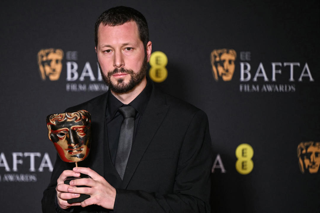 Ukrainian photojournalist Mstyslav Chernov poses with the award for Best documentary for 