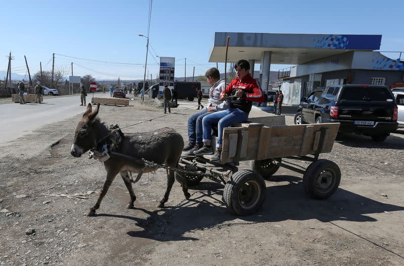 FILE PHOTO: Boys sit on a donkey-drawn cart near a check point in Marneuli