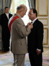 François Hollande reçoit l'insigne de Grand maître de l'Ordre de la Légion d'honneur avant de signer un registre avant de se rendre, entouré du président du Sénat et du président de l'Assemblée nationale, dans la salle des fêtes où l'attendent tous ses invités. AFP