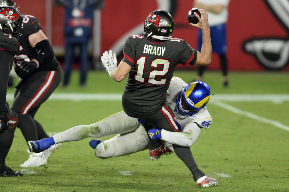 El linebacker Samson Ebukam (50), de los Rams de Los Ángeles, atrapa al quarterback Tom Brady (12), de los Buccaneers de Tampa Bay, en la segunda mitad del partido de la NFL en Tampa, Florida, el lunes 23 de noviembre de 2020. (AP Foto/Jason Behnken)