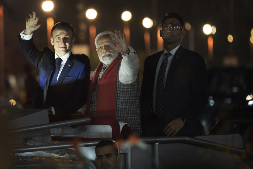 French President Emmanuel Macron, left, and Indian Prime Minister Narendra Modi greet people lining the streets as they ride an open vehicle together during a road show in Jaipur, Rajasthan, India, Thursday, Jan. 25, 2024. Macron will be the chief guest at India's annual republic day parade in New Delhi on Friday. (AP Photo/ Deepak Sharma)