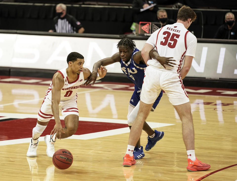 Wisconsin's D'Mitrik Trice (0) drives against Eastern Illinois' Junior Farquhar (5) as Wisconsin's Nate Reuvers (35) sets a screen during the second half of an NCAA college basketball game Wednesday, Nov. 25, 2020, in Madison, Wis. Wisconsin won 77-67. (AP Photo/Andy Manis)