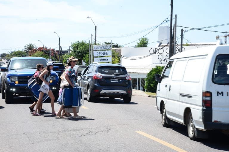 Turistas cruzan la ruta 10 en dirección a las playas de La Barra