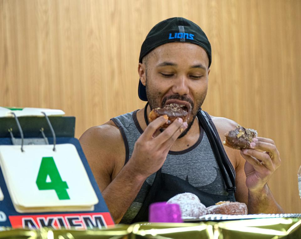 Akiem Harshman representing Judson Baptist Church is on his way to winning the inaugural Quality Dairy paczki-eating contest by finishing four of the pastries in three minutes Friday, Jan. 26, 2024.