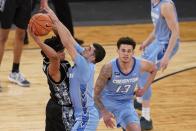 Georgetown's Dante Harris, left, passes away from Creighton's Marcus Zegarowski, center, and Christian Bishop, right, during the second half of an NCAA college basketball game in the championship of the Big East Conference tournament Saturday, March 13, 2021, in New York. (AP Photo/Frank Franklin II)