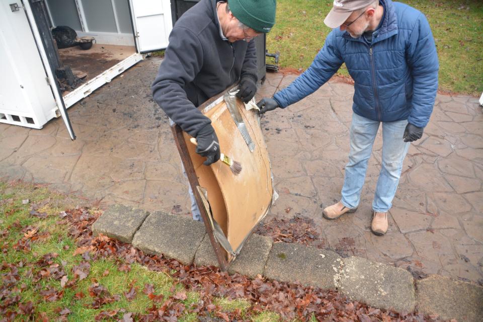 John Duckworth, left, and Bryan Menke examine a framed picture. Many artifacts were damaged during the October fire at Stow Heritage House.