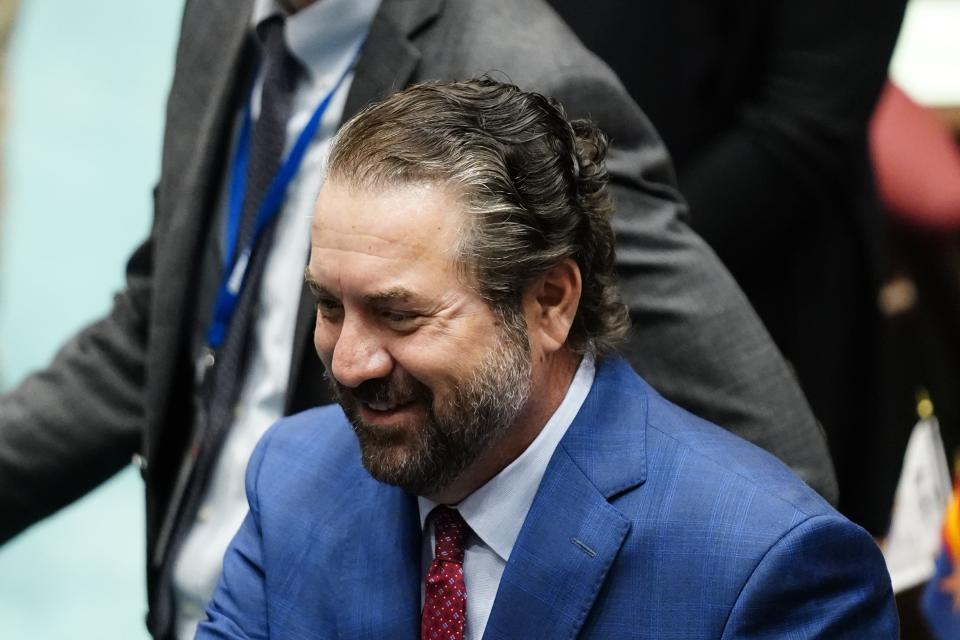 Mark Brnovich, a Republican running for US Senate, smiles as he talks with people on the floor of the Arizona House of Representatives, at the Arizona Capitol, Jan. 10, 2022, in Phoenix. (AP Photo/Ross D. Franklin)