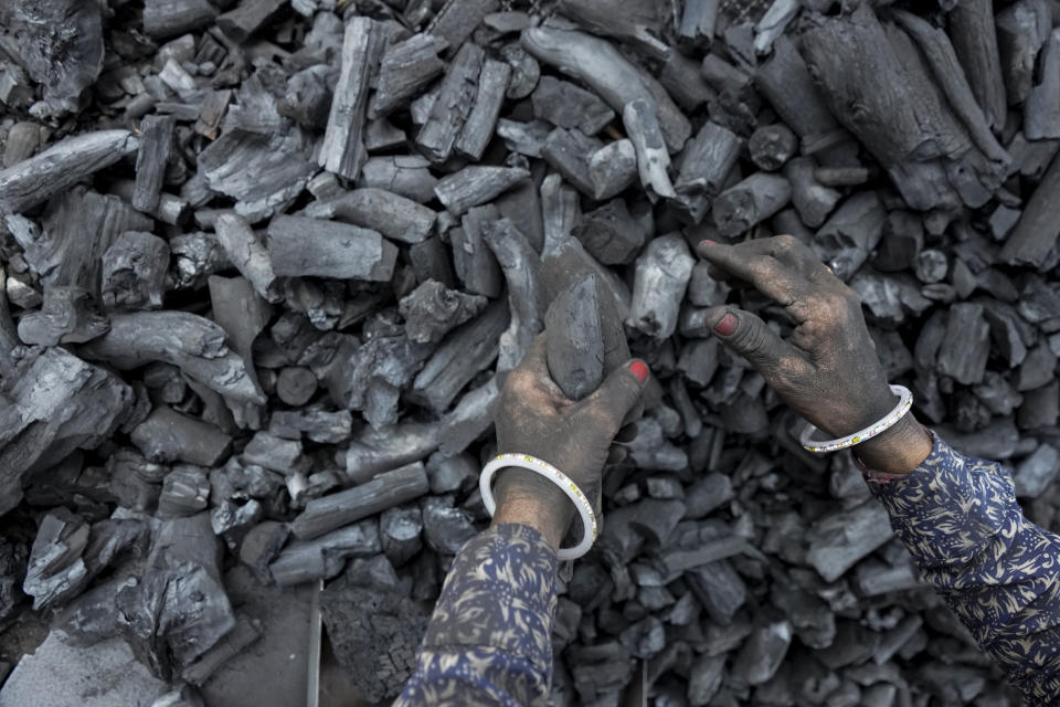 FILE - A woman works at a coal depot in Ahmedabad, India, Monday, May 2, 2022. (AP Photo/Ajit Solanki, File)