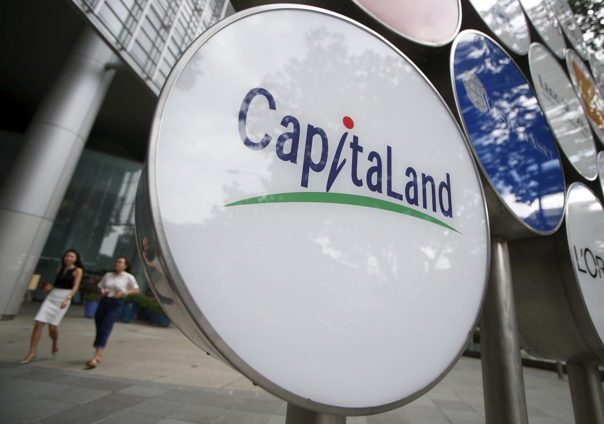 People pass a Capitaland logo in the central business district in Singapore. (Photo:REUTERS/Edgar Su)