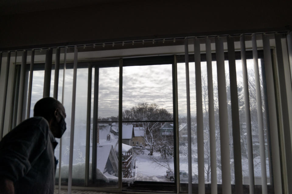 Ulysses Underwood, 66, looks out his apartment window after his weekday visit from Ethos Meals on Wheels in Hyde Park, Mass., Friday, Dec. 18, 2020. Underwood started receiving the meals in May after moving to the area and was in need of greater financial assistance for food. "There are times that growing old gets hectic," said Underwood who struggles with scoliosis and has trouble walking long distances. "One has to look forward to other assistance besides trying to do it alone." (AP Photo/David Goldman)