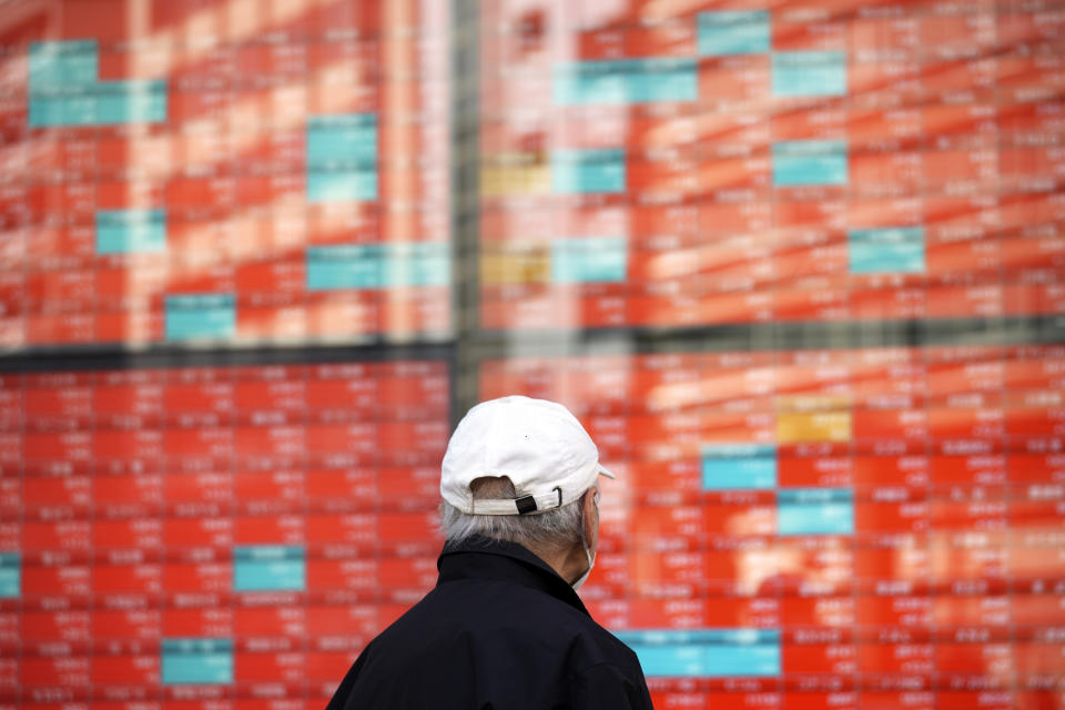 FILE - A person walks in front of an electronic stock board showing Japan's Nikkei 225 index at a securities firm in Tokyo, Jan. 22, 2024. Asian markets were mostly higher Wednesday, March 20, 2024 ahead of expected guidance by the Federal Reserve on the timing of its cuts to interest rates. (AP Photo/Eugene Hoshiko, File)