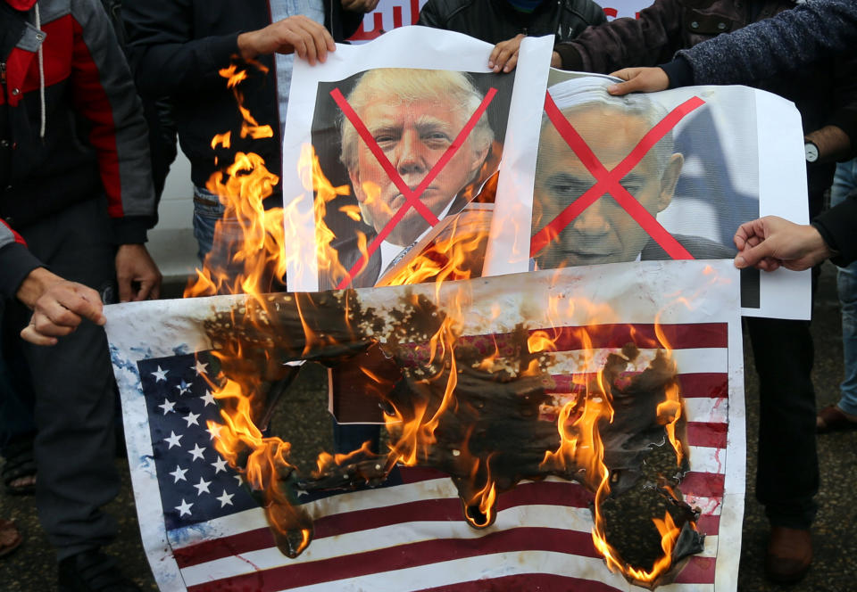 Palestinians burn posters depicting Israeli Prime Minister Benjamin Netanyahu and Trump during the Rafah protest.