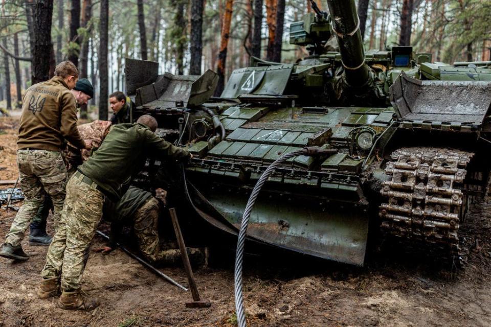 A group of Ukrainian soldiers checking their tank after action.