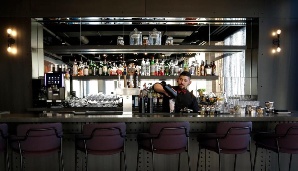 Bartender Justin Silmon pours a drink at the bar of the Blu Violet restaurant on the seventh floor at Aloft, the city's newest hotel.