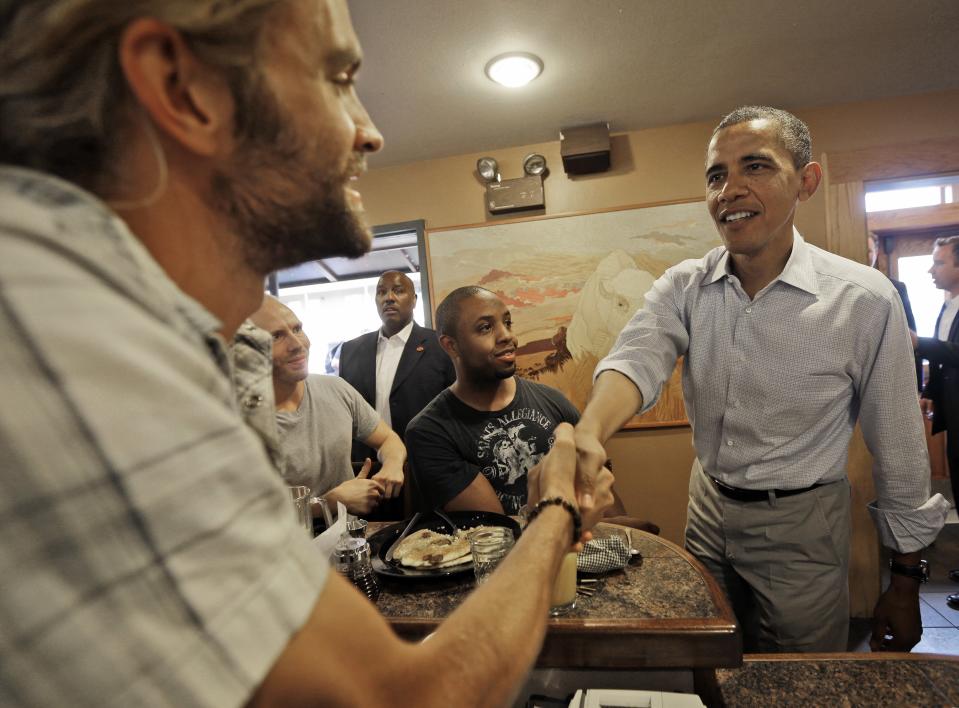President Barack Obama, right, greets employees and patrons at the Buff Restaurant, during an unscheduled stop, Sunday, Sept. 2, 2012, in Boulder, Colo. (AP Photo/Pablo Martinez Monsivais)