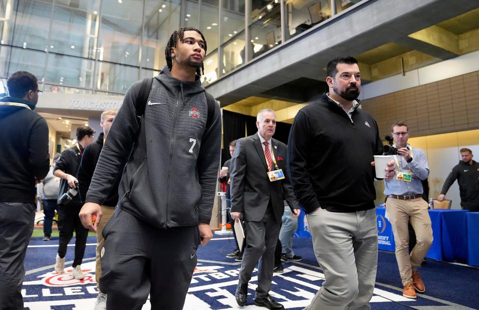 Dec 29, 2022; Atlanta, GA, USA; Ohio State Buckeyes quarterback C.J. Stroud (7) and Ohio State Buckeyes head coach Ryan Day walk into media day for the Peach Bowl at the College Football Hall of Fame. 