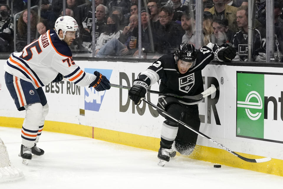 Los Angeles Kings center Trevor Moore, right, falls as he tries to play the puck while under pressure from Edmonton Oilers defenseman Evan Bouchard during the second period in Game 6 of an NHL hockey Stanley Cup first-round playoff series Thursday, May 12, 2022, in Los Angeles. (AP Photo/Mark J. Terrill)