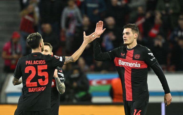 Bayer Leverkusen's Czech forward #14 Patrik Schick (C) celebrates scoring the 3-2 goal with team mate Bayer Leverkusen's Argentine midfielder #25 Exequiel Palacios during the UEFA Europa League Group round of 16, second-leg football match between Bayer 04 Leverkusen and Garabagh in Leverkusen, western Germany on March 14, 2024. (Photo by INA FASSBENDER / AFP)