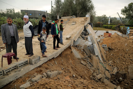 Palestinians stand on the remains of a building that was destroyed in an Israeli air strike, in Khan Younis in the southern Gaza Strip November 12, 2018. REUTERS/Suhaib Salem