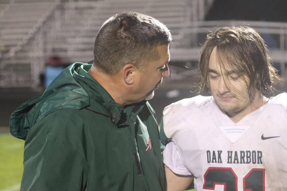 Oak Harbor coach Mike May talks to senior Dalton Witter about shared experiences.