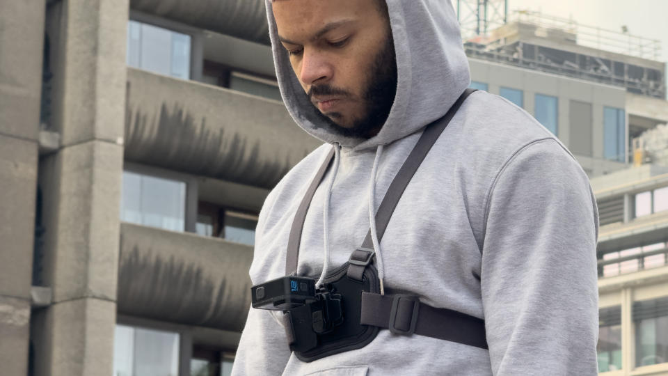 A camera strapped to a harness on a man's chest