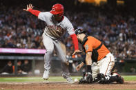 Cincinnati Reds' Nick Senzel scores against San Francisco Giants catcher Curt Casali during the fifth inning of a baseball game in San Francisco, Friday, June 24, 2022. (AP Photo/John Hefti)