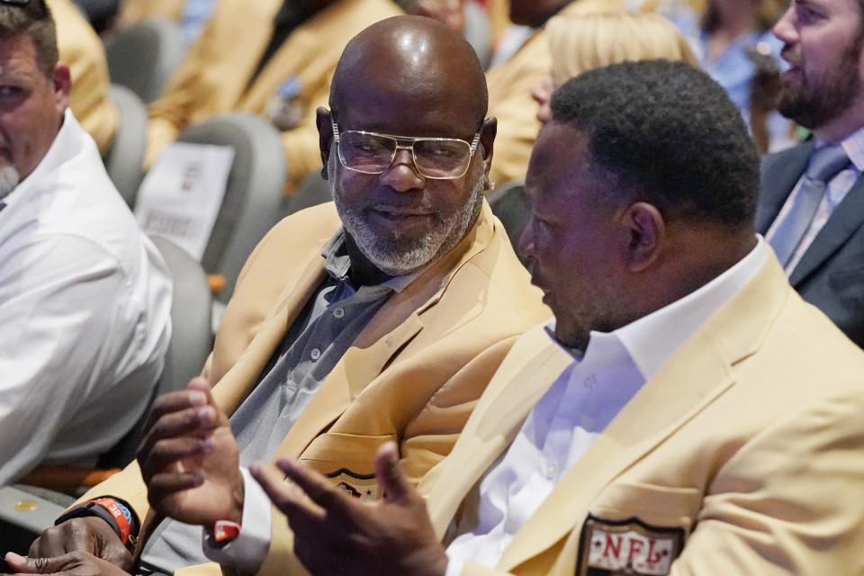 NFL Hall of Fame members Emmit Smith, left, and Barry Sanders, right, talk before a tribute to the late NFL player Jim Brown Thursday, Aug. 3, 2023, in Canton, Ohio. (AP Photo/Sue Ogrocki)
