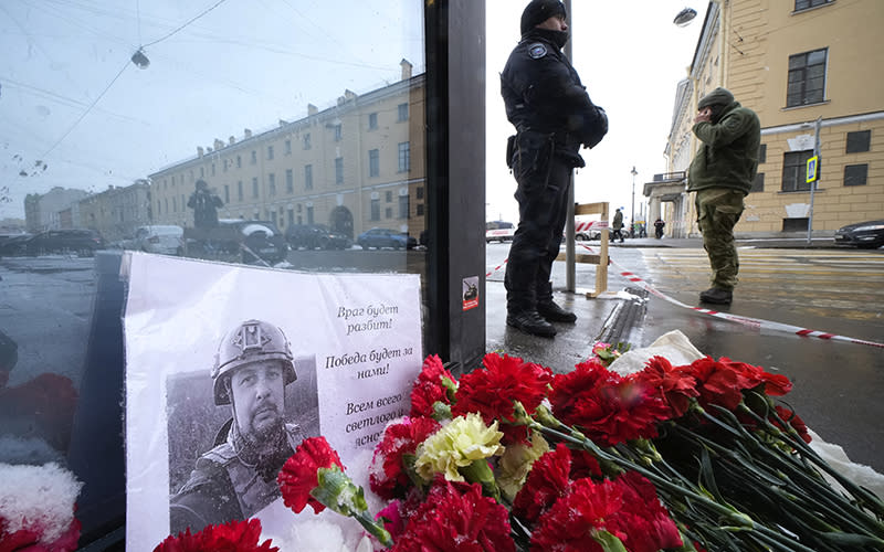 Flowers and a poster with a photo of blogger Vladlen Tatarsky placed near the site of an explosion at the "Street Bar" cafe in St. Petersburg, Russia