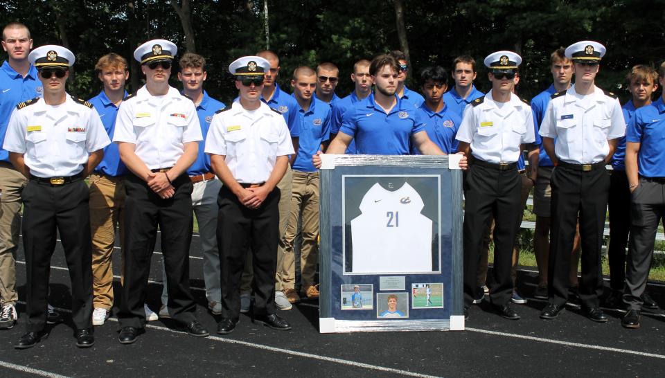 Five of Brian Kenealy's closest teammates at Maine Maritime Academy stand at attention in their regimental uniforms during Saturday's ceremony at York High School to officially retire Kenealy's No. 21.