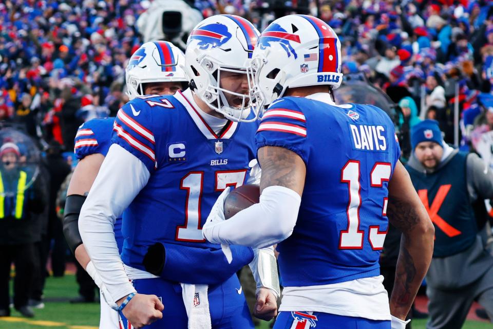 El receptor abierto de los Buffalo Bills, Gabe Davis (13), a la derecha, es felicitado por el mariscal de campo Josh Allen después de su atrapada de touchdown durante la segunda mitad del juego de comodines contra los Miami Dolphins.