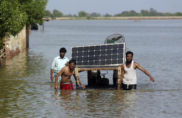 Victims of unprecedented flooding salvage belongings from their home in Jaffarabad, Pakistan