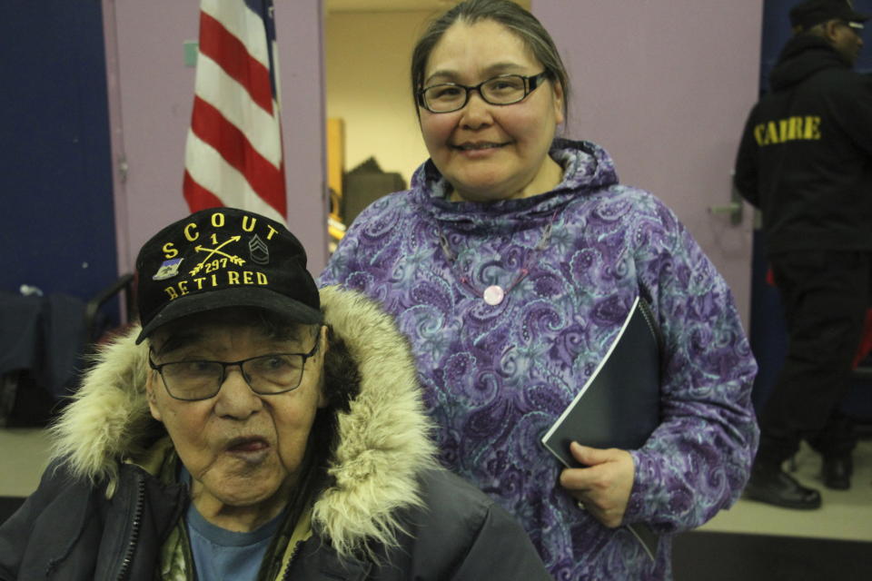 This March 28, 2023, photo shows Bruce Boolowon, left, posing with his eldest daughter, Rhona Pani Apassingok, at an Alaska National Guard ceremony in Gambell, Alaska. Maj. Gen. Torrence Saxe, the adjutant general of the Alaska National Guard, presented Alaska Heroism Medals to Boolowon, the last surviving guardsman of 16 who helped rescue 11 Navy crewmen after they crash landed on St. Lawrence Island on June 22, 1955, and to the family members of 15 other guardsman who are now deceased. (AP Photo/Mark Thiessen)
