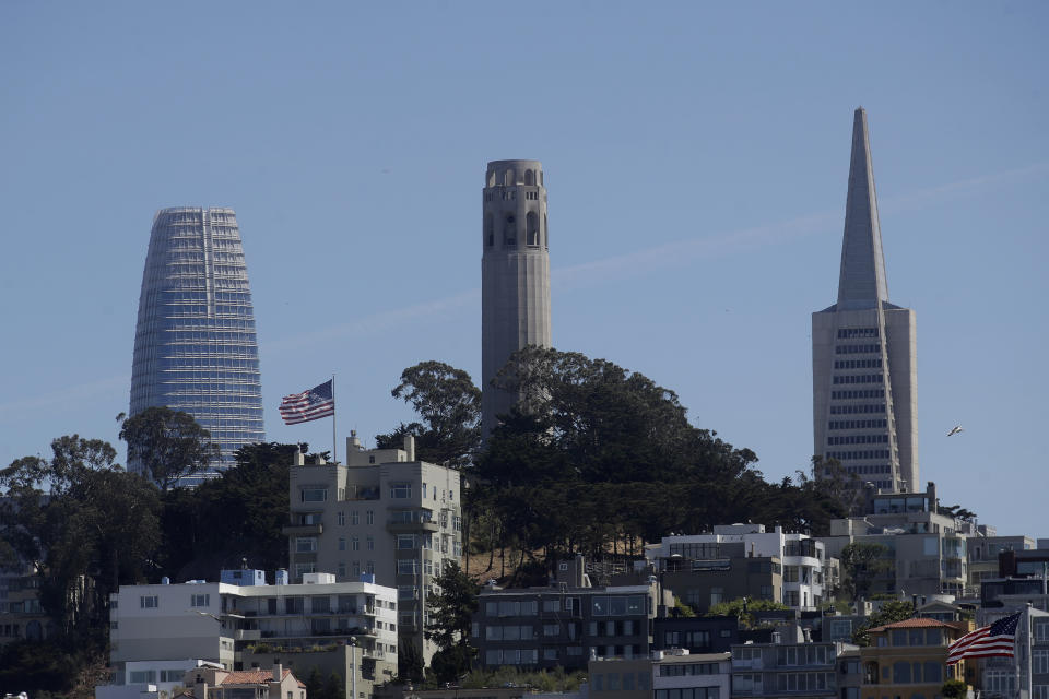 FILE - In this June 18, 2020, file photo, Coit Tower, center, is seen between Salesforce Tower, left, and the Transamerica Pyramid from Pier 39 in San Francisco. The Transamerica Pyramid, one of San Francisco's iconic buildings, has sold for $650 million, eight months after a sales agreement was reached. (AP Photo/Jeff Chiu, File)